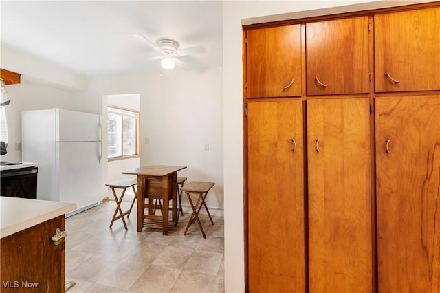 449 W Long Lake Blvd, Akron, OH 44319 - kitchen with brown cabinetry, a ceiling fan, electric range oven, light countertops, and freestanding refrigerator