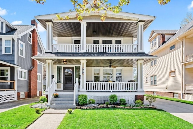 view of front of property with a front lawn, ceiling fan, a balcony, and covered porch
