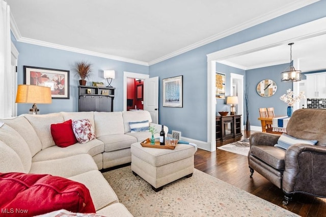 living area with baseboards, crown molding, and wood finished floors