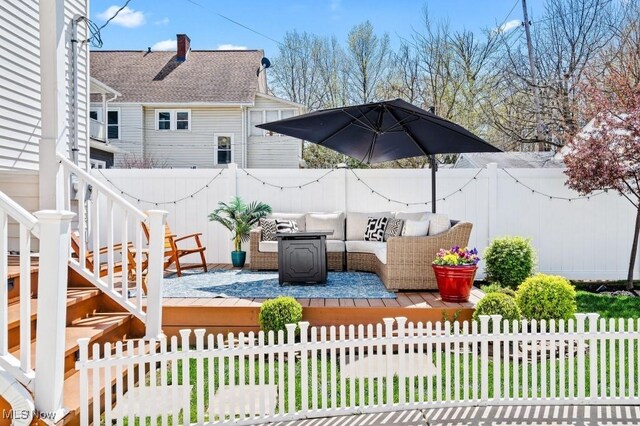 view of patio featuring a deck, an outdoor living space, and a fenced backyard