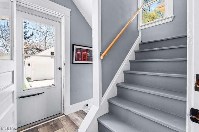 interior space featuring baseboards, wood finished floors, and stairway