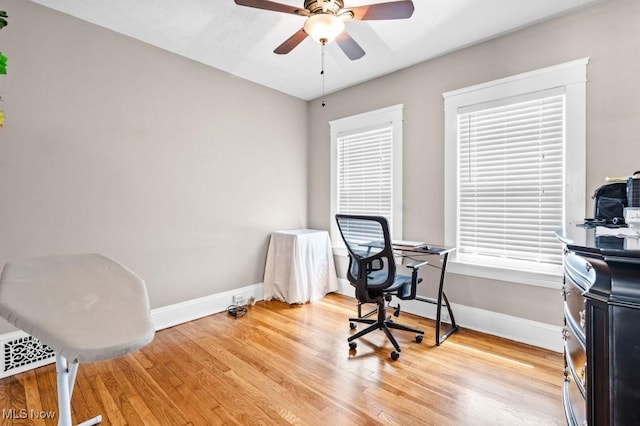 office with baseboards, a ceiling fan, and light wood-type flooring