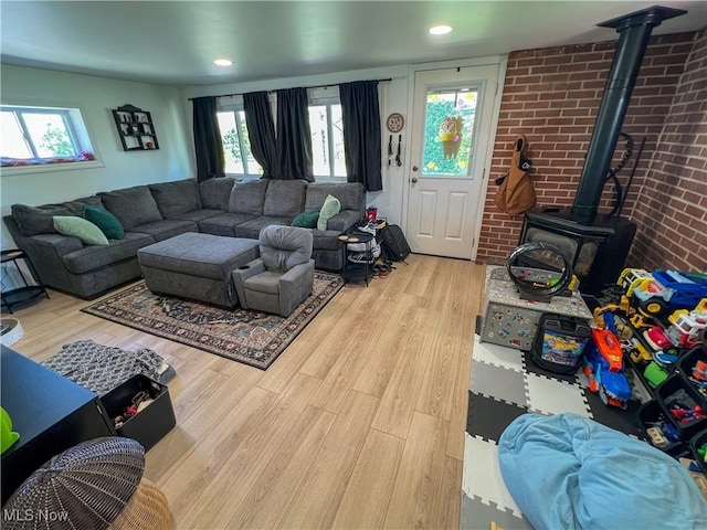 living room with recessed lighting, wood finished floors, and a wood stove