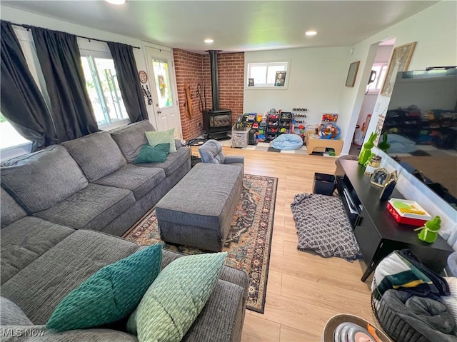 living room with a wood stove, recessed lighting, and wood finished floors