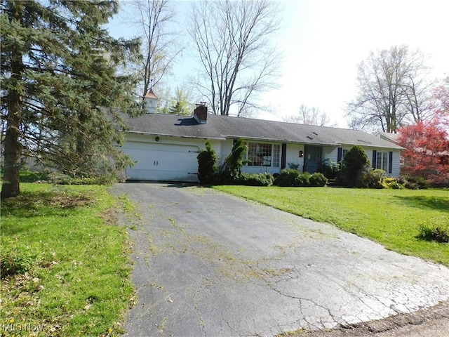 ranch-style home with a garage, a chimney, driveway, and a front lawn