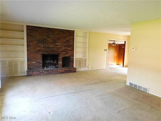 unfurnished living room featuring a fireplace, built in features, carpet, and visible vents
