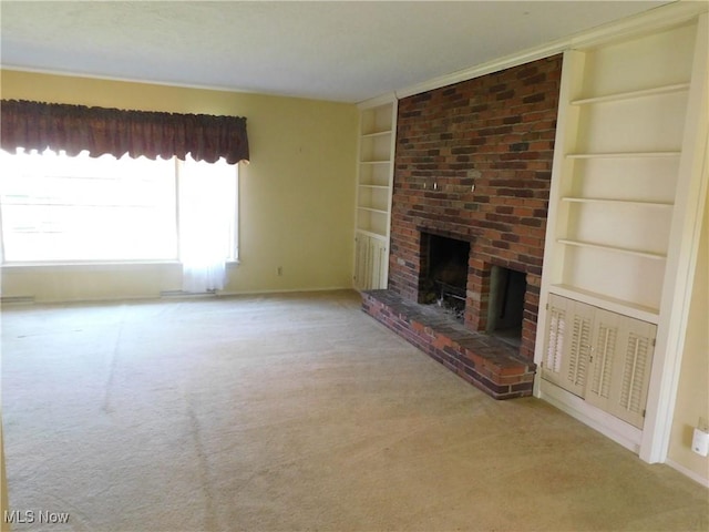 unfurnished living room featuring carpet floors, baseboards, a fireplace, and built in shelves