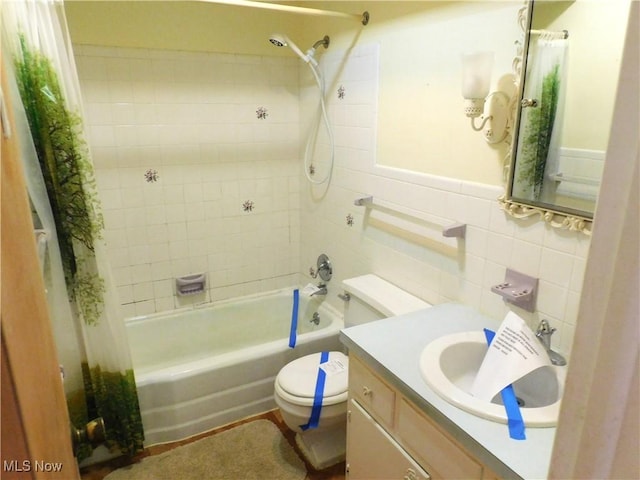 bathroom with vanity, shower / bathtub combination with curtain, toilet, and tile walls