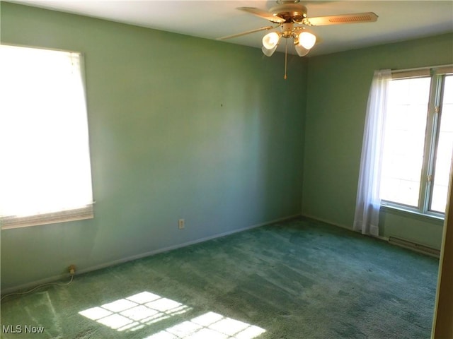 carpeted spare room featuring baseboards and ceiling fan
