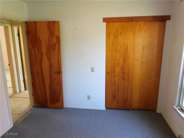 unfurnished bedroom with carpet and a closet