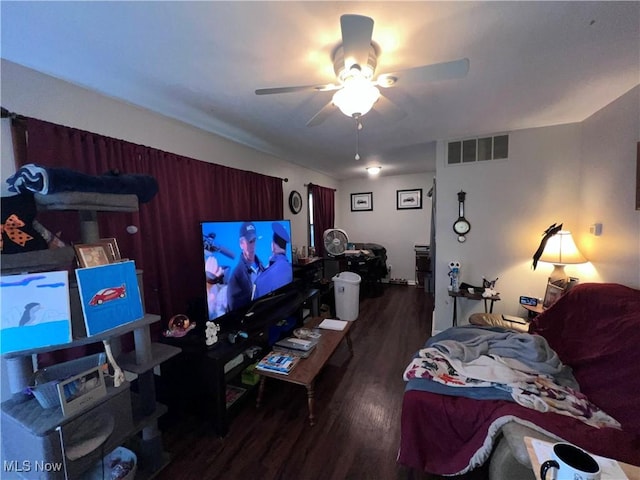 living area featuring a ceiling fan, visible vents, and wood finished floors