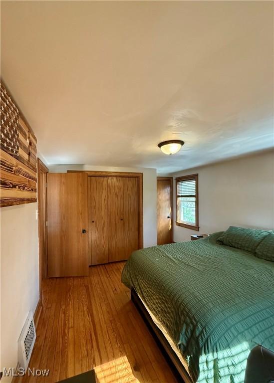 bedroom with visible vents and hardwood / wood-style flooring