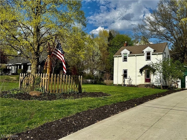 view of side of property with a lawn, fence, and a chimney