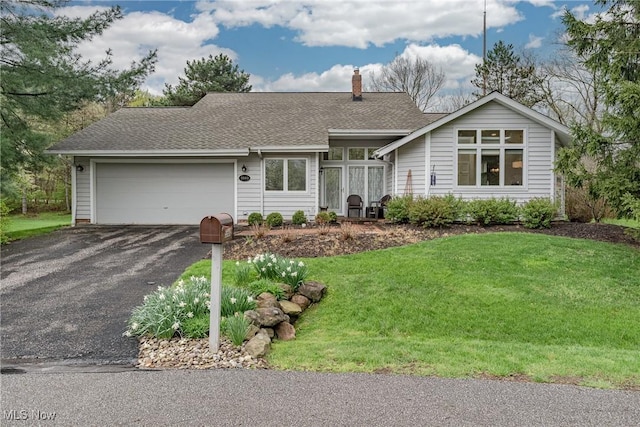 ranch-style house with driveway, a chimney, a front yard, roof with shingles, and a garage