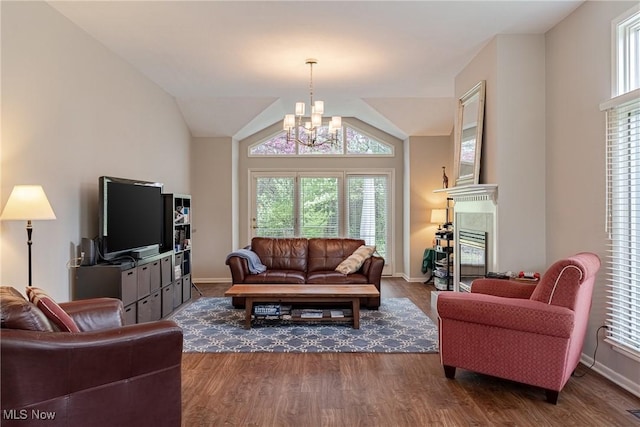 living area featuring baseboards, a notable chandelier, and dark wood-type flooring