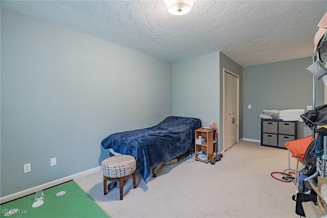 bedroom with baseboards, carpet flooring, and a textured ceiling