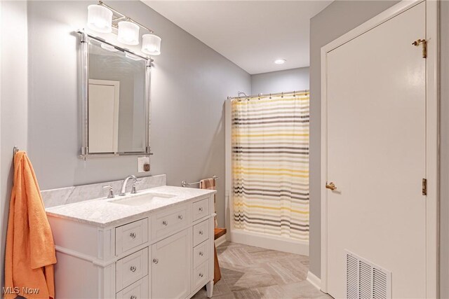 full bathroom with visible vents, baseboards, curtained shower, and vanity