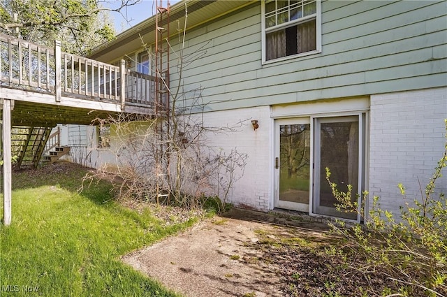 view of side of property with brick siding, stairway, and a deck