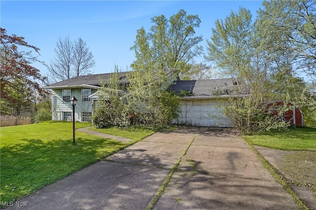 view of front facade featuring concrete driveway and a front yard