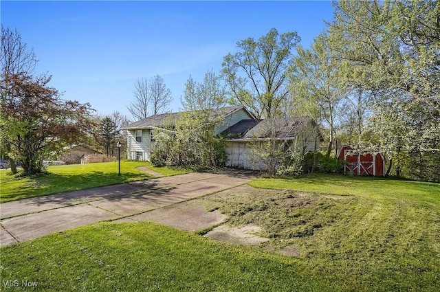view of front of house featuring concrete driveway, an outbuilding, a front yard, and a storage unit