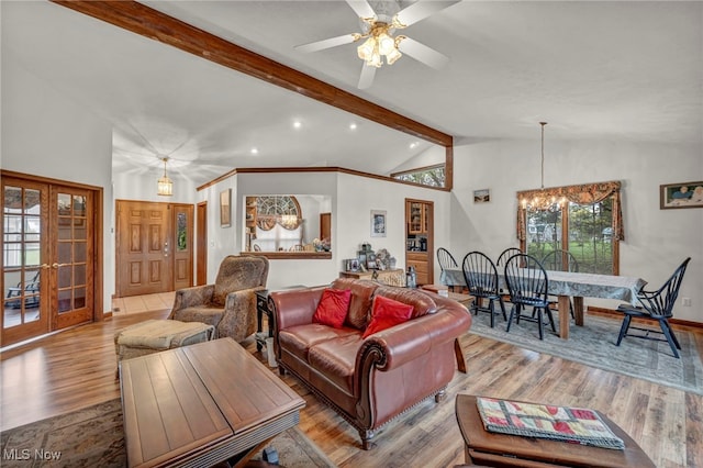 living area featuring french doors, ceiling fan with notable chandelier, recessed lighting, wood finished floors, and beamed ceiling