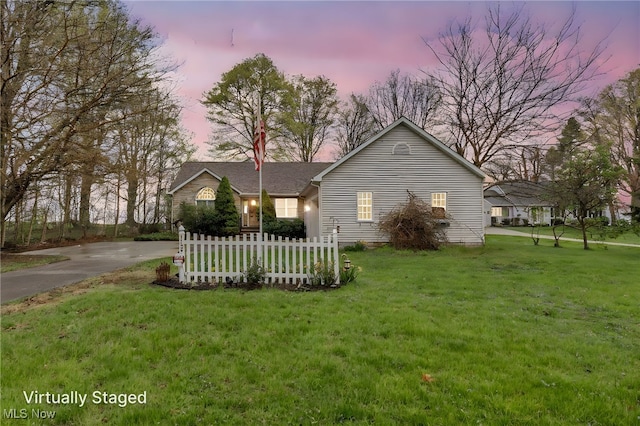 view of front of house with a front lawn, fence, and driveway