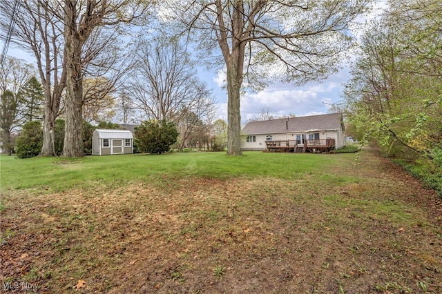 view of yard featuring a storage shed, an outdoor structure, and a deck
