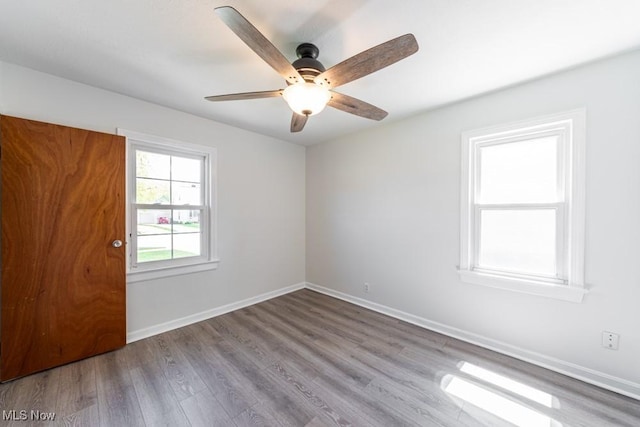 empty room with baseboards, ceiling fan, and wood finished floors