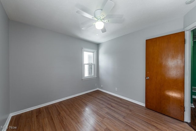 unfurnished room featuring baseboards, ceiling fan, and wood finished floors