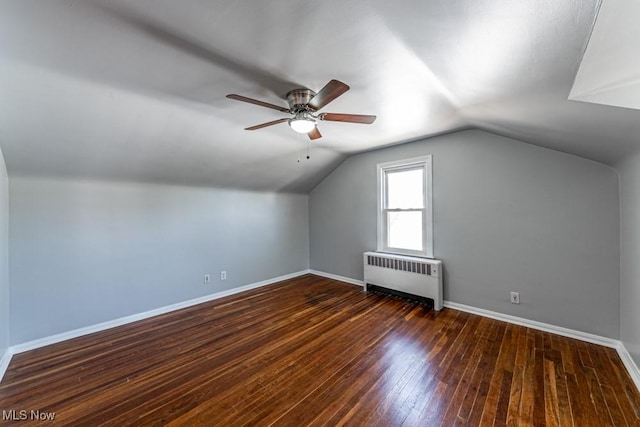 additional living space with baseboards, wood-type flooring, ceiling fan, and radiator heating unit