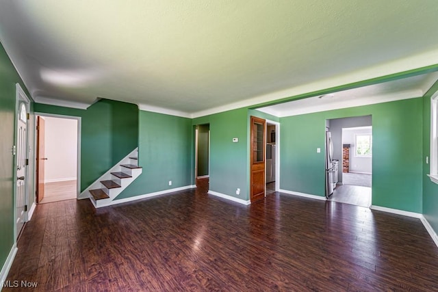 spare room with stairs, baseboards, and wood finished floors