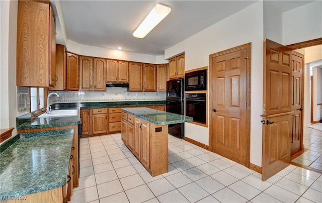 kitchen with brown cabinetry, dark countertops, a sink, black appliances, and light tile patterned flooring
