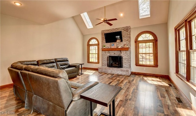 living area with a skylight, baseboards, ceiling fan, and visible vents