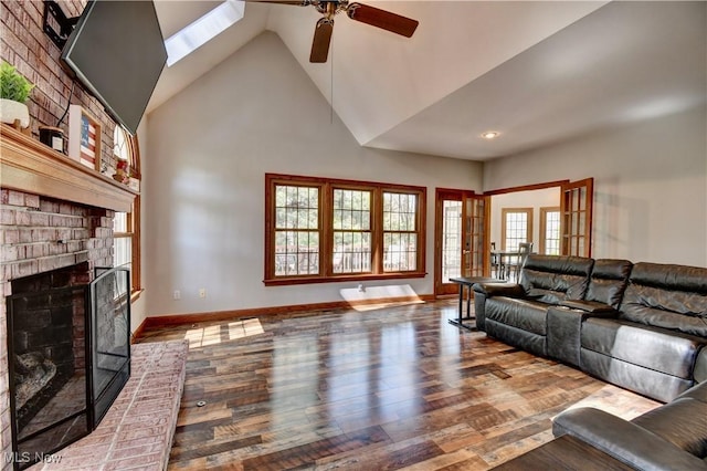 living area featuring a brick fireplace, a ceiling fan, high vaulted ceiling, and wood finished floors