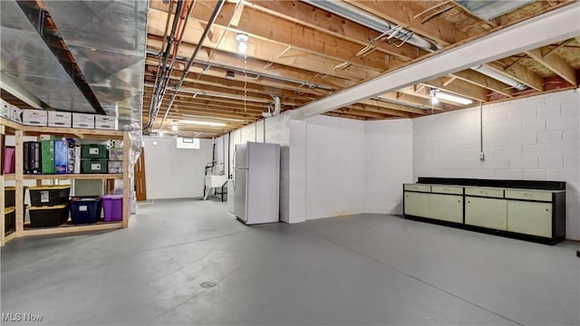 below grade area featuring freestanding refrigerator