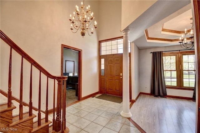 foyer entrance featuring stairway, baseboards, and a notable chandelier