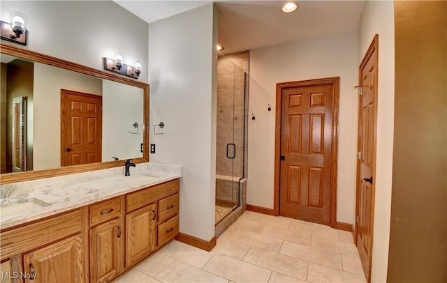 bathroom with a sink, double vanity, tile patterned floors, baseboards, and a stall shower