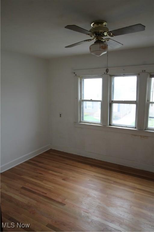 unfurnished room with baseboards, light wood finished floors, and a healthy amount of sunlight