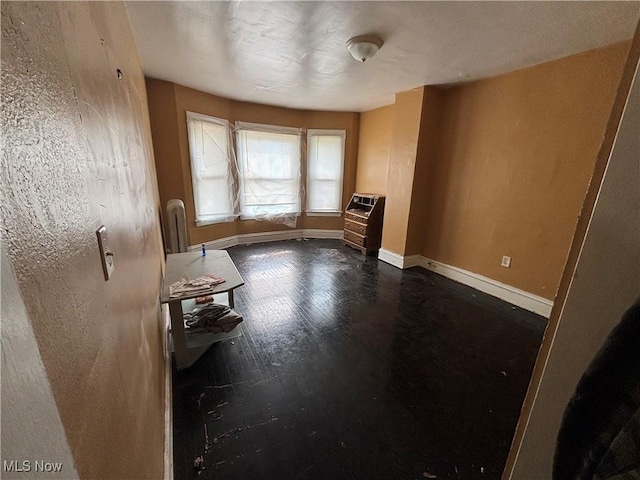interior space featuring baseboards, dark wood-type flooring, and radiator