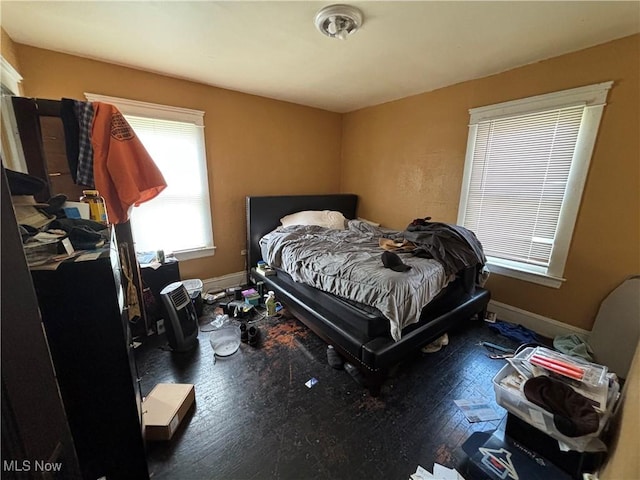 bedroom with baseboards and wood finished floors