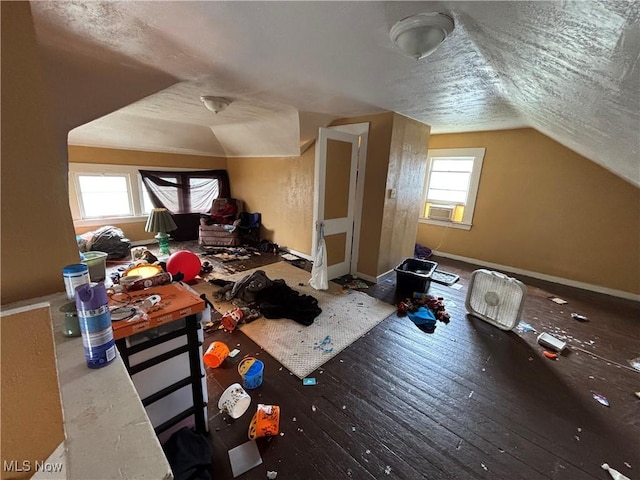 additional living space with baseboards, vaulted ceiling, hardwood / wood-style flooring, and cooling unit