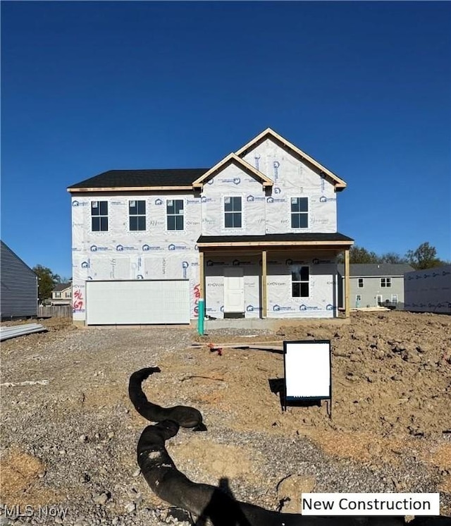 view of front of property with a garage and gravel driveway