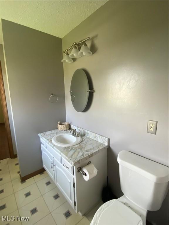 8995 Sarbaugh Rd, Norwich, OH 43767 - bathroom with toilet, a textured ceiling, tile patterned flooring, and vanity