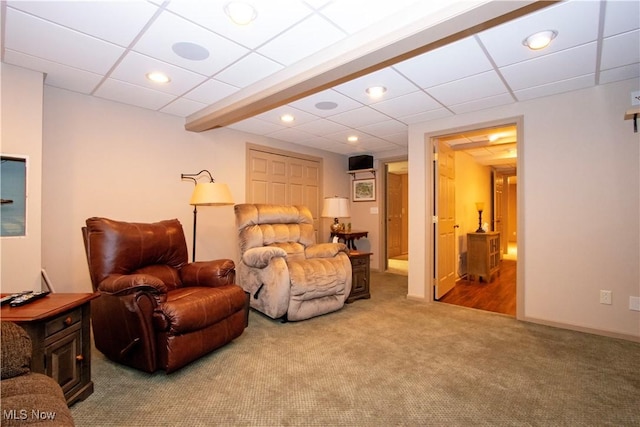 living area with recessed lighting, a drop ceiling, and carpet