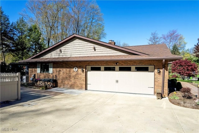 exterior space featuring brick siding, an attached garage, driveway, and a chimney