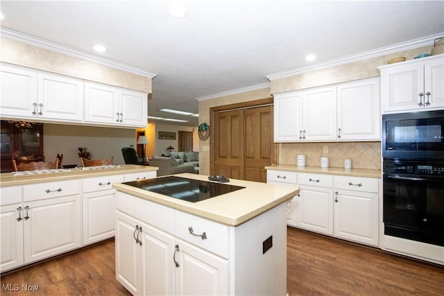 kitchen featuring crown molding, light countertops, black appliances, and dark wood finished floors