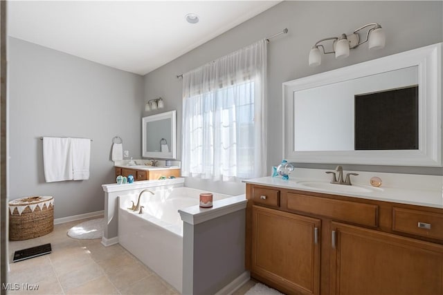 bathroom with vanity, baseboards, and a bath