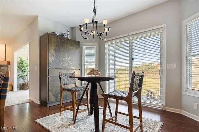 dining room with baseboards, a notable chandelier, and dark wood-style floors