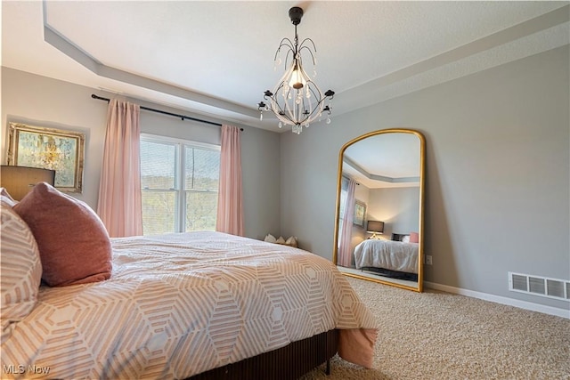 bedroom with visible vents, carpet floors, baseboards, a raised ceiling, and a chandelier