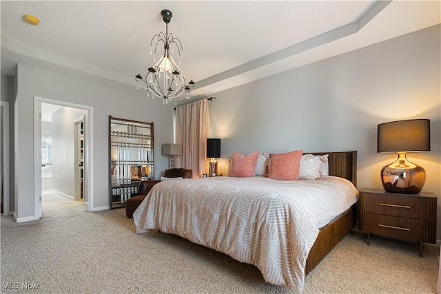 bedroom featuring an inviting chandelier, baseboards, carpet flooring, and a tray ceiling